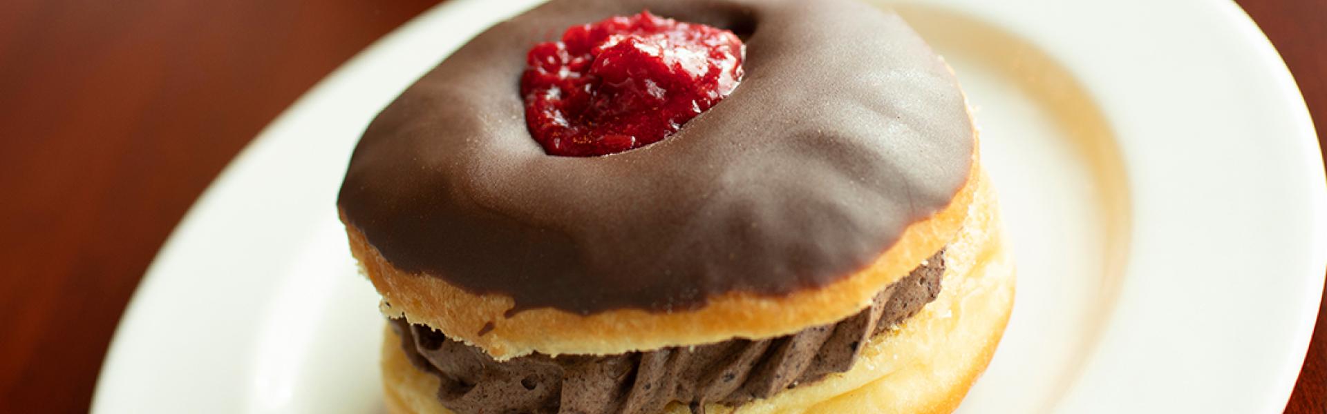 Plate of specialty cream donut with strawberry topping 