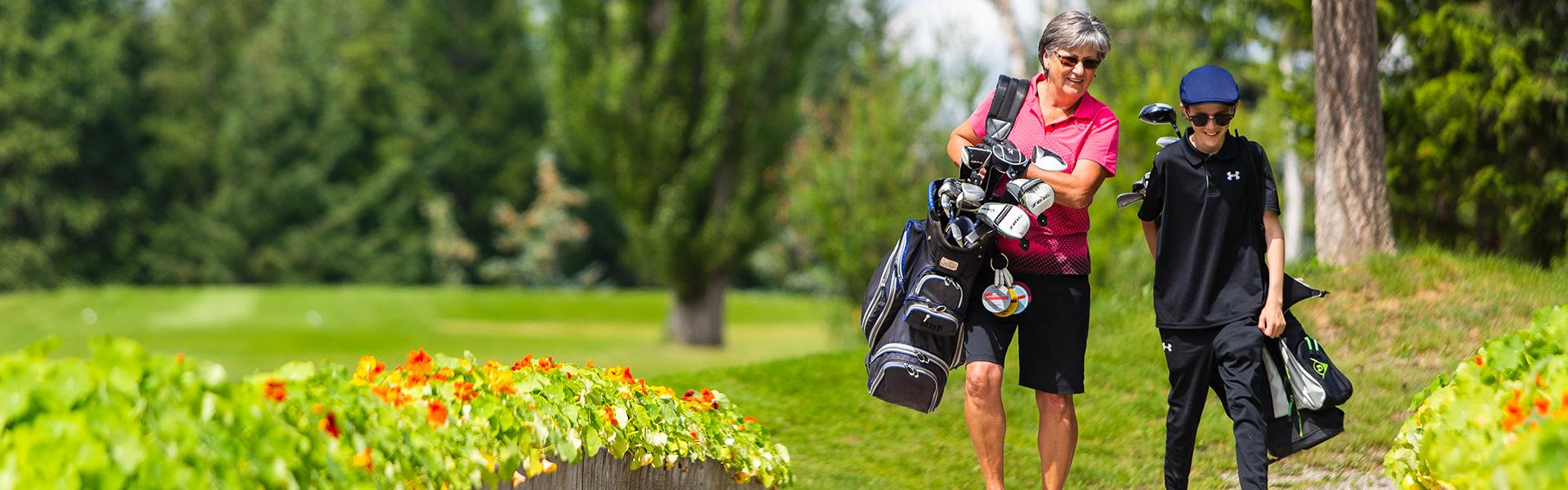 Grandma and grandson carrying their golf bags