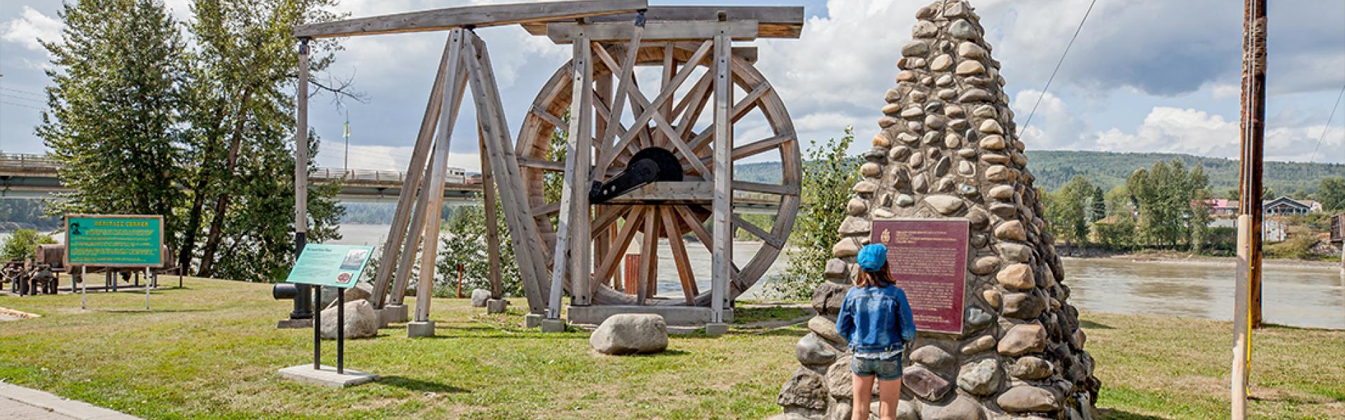 Young girl reading interpretive signage at Heritage Corner in Quesnel