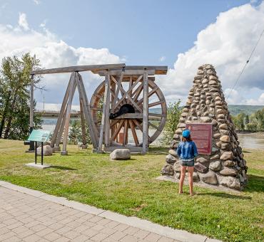 Young girl reading interpretive signage at Heritage Corner in Quesnel