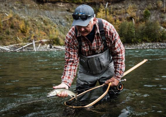 Man catching fish in river with net